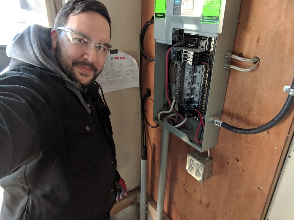 image of Jason from Kite Electric standing in front of an electrical panel