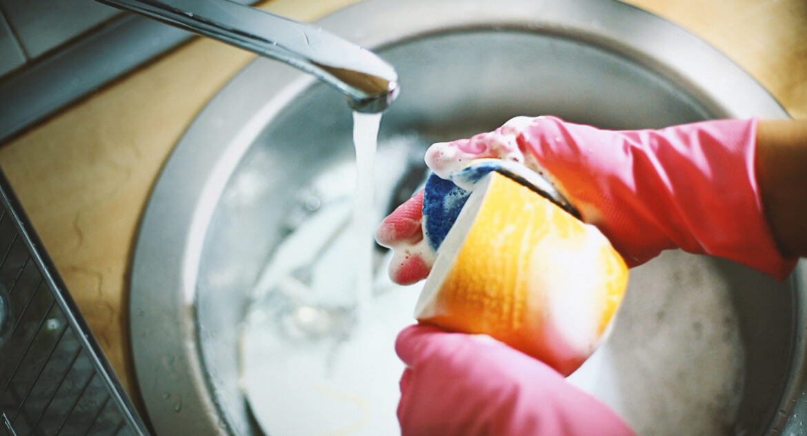 Cleaning Ladies - person washing mug in sink