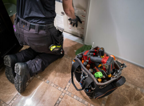 Photo of an HVAC technician servicing equipment and following an HVAC inspection checklist